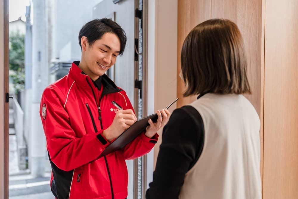 玄関先で内容を聞き取るおそうじ革命のスタッフ